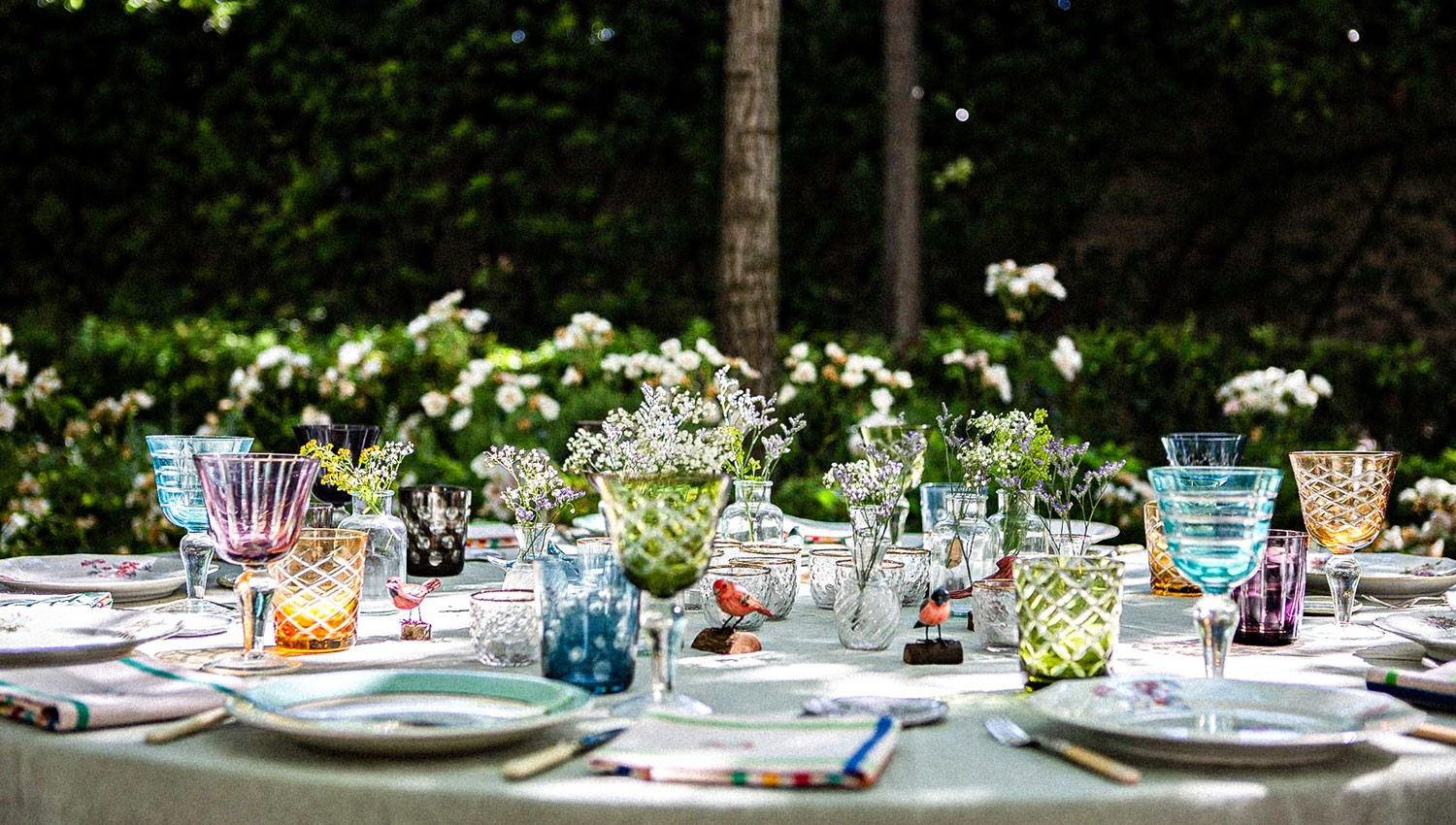 Table extérieure décorée de fleurs et de vaisselle.